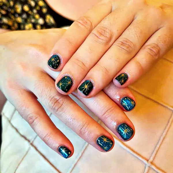 Dark green nails with gold stars by Sandy Hill Spa