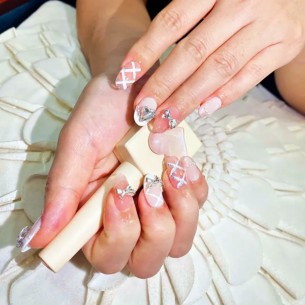 White ribbon nail art with bow charms by Sandy Hill Spa